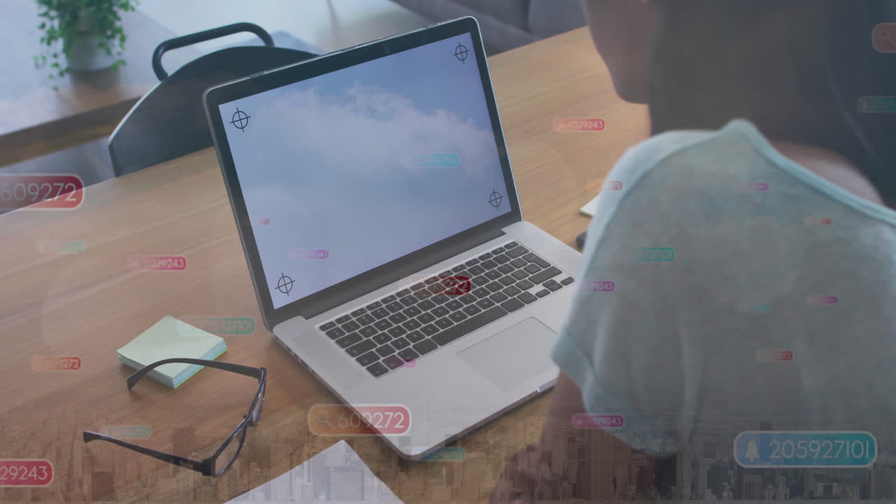 Working on laptop, person receiving animation of social media notifications