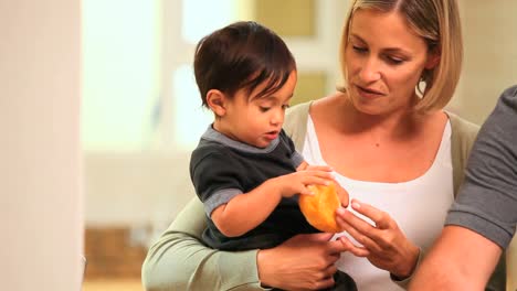 Baby-Mit-Eltern,-Die-Ein-Brötchen-Halten