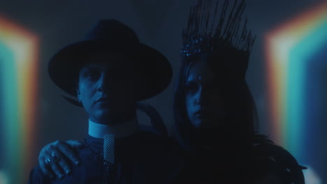 woman in gothic crown and man in priest costume