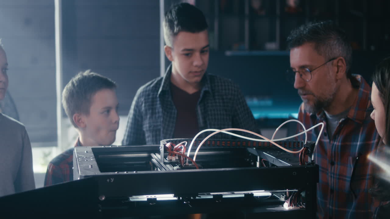 Students learning 3D printing with a teacher