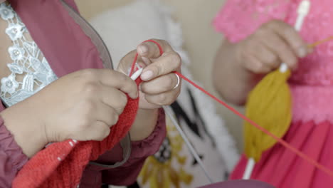 hands of indigenous women working with wool thread