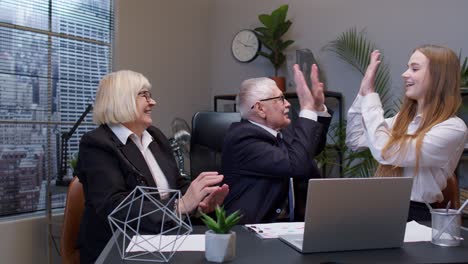 company collegues joining hands give high five in air celebrating corporate unity success at office