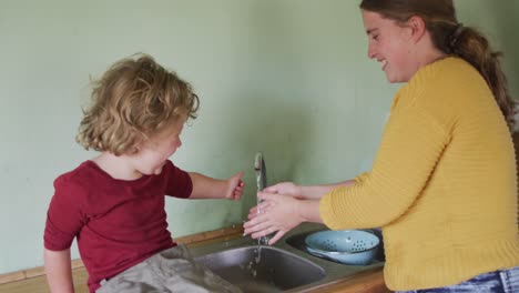 Glückliche-Kaukasische-Mutter-Und-Sohn-Waschen-Sich-In-Der-Küche-Die-Hände