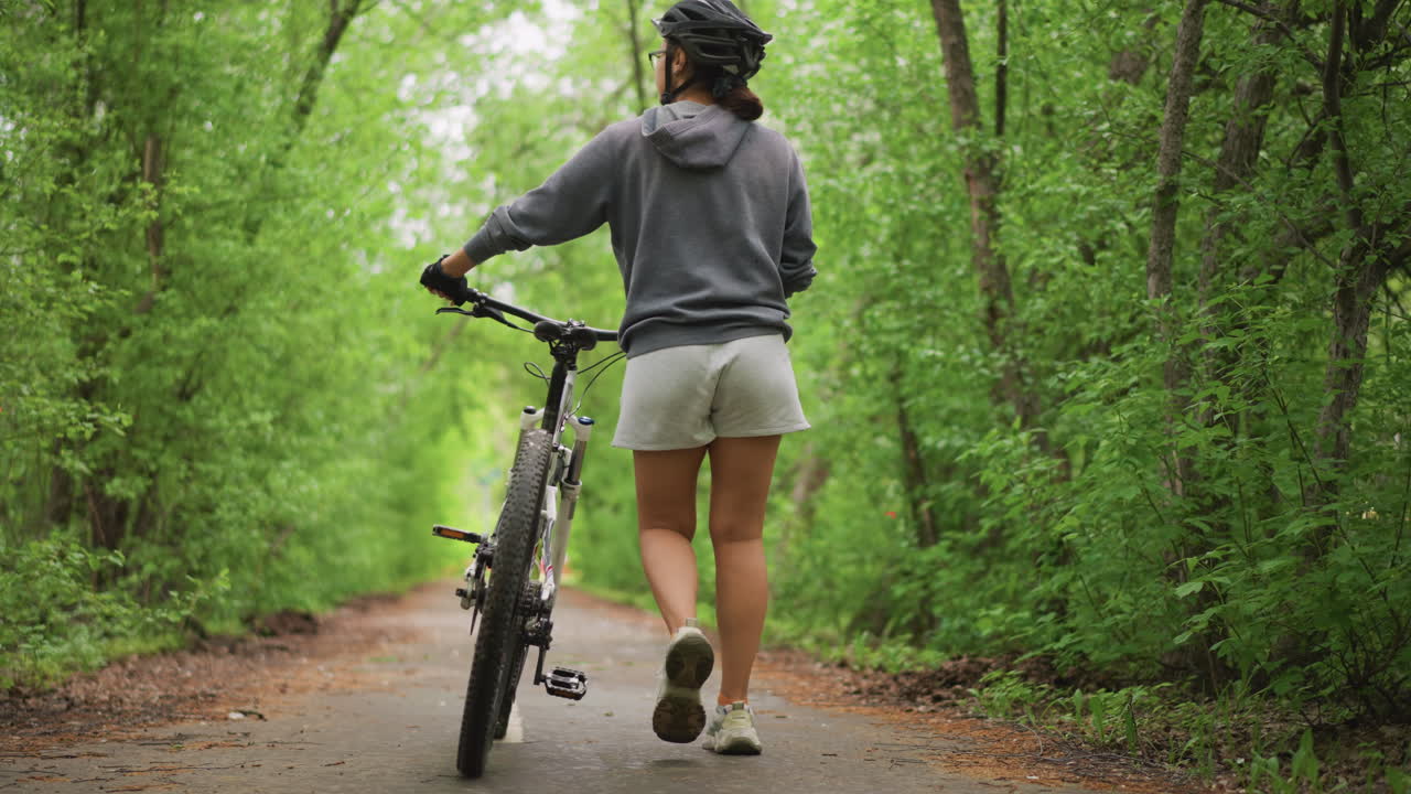 Cyclist In Forest, Enthusiastic Cyclist Wearing Helmet Exploring Shaded Woodland Route Carefully, Determined Rider With Protective Gear Advances Along Treelined Trail Thoughtfully And Slowly