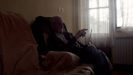 old man browsing through apps on his tablet computer