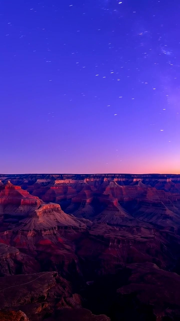 Video verticale: Illuminazione mutevole del canyon e della Via Lattea mentre il bagliore dell'alba sorge dal bordo, mesas che si riscaldano.