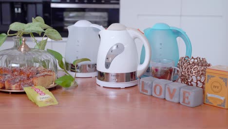 tilt up shot of selection of electric kettles, decorative kitchen scene