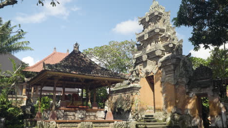 ornamented angkul doors and pavilion with royal chair inside ubud palace, puri saren agung - historical balinese architecture in ubud, gianyar regency of bali, indonesia - tilt down pan reveal