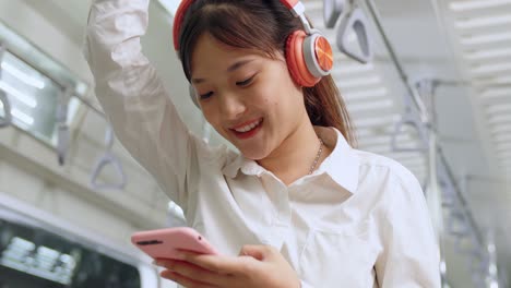 young woman using mobile phone on public train