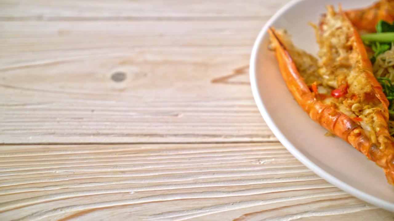 fideos de arroz salteados y mimosa de agua con gambas de río