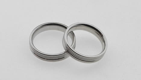 silver wedding rings overlap each other