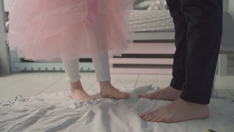 Little daughter dances on her daddy&#039;s feet at home. Father&#039;s day.