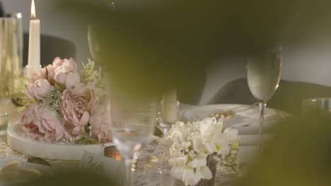 close up of person pouring champagne into glass at table set for meal at wedding reception 2