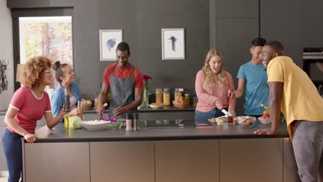 Happy-diverse-group-of-friends-preapring-meal-in-kitchen,-slow-motion