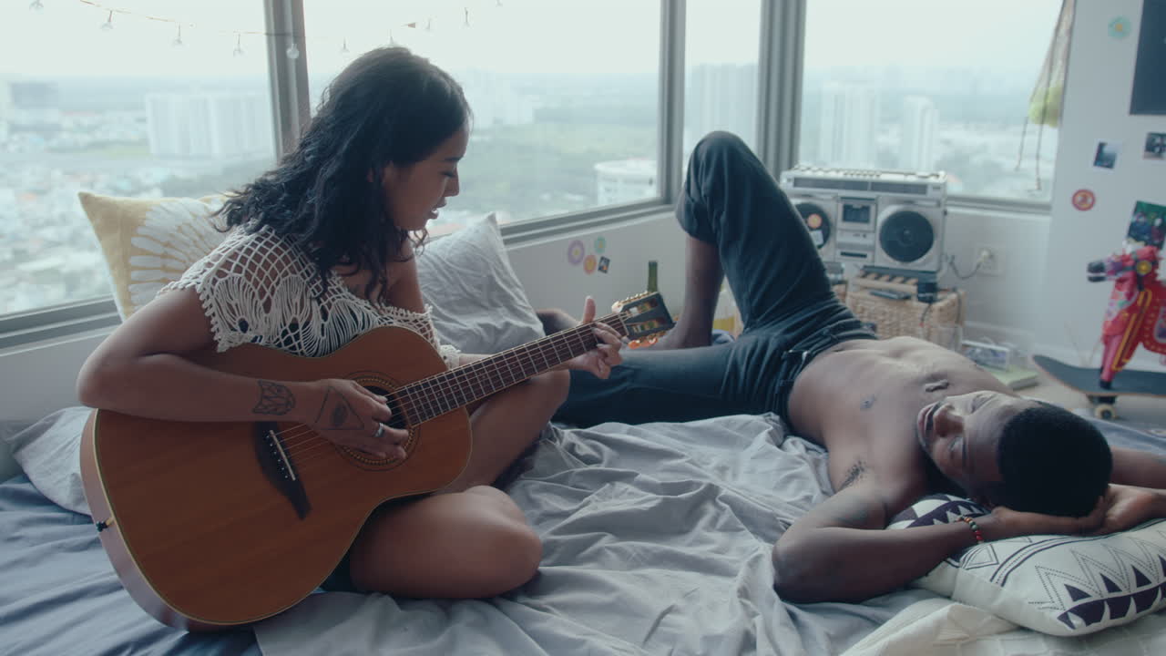 Girl Singing and Playing the Guitar For Her Boyfriend at Home