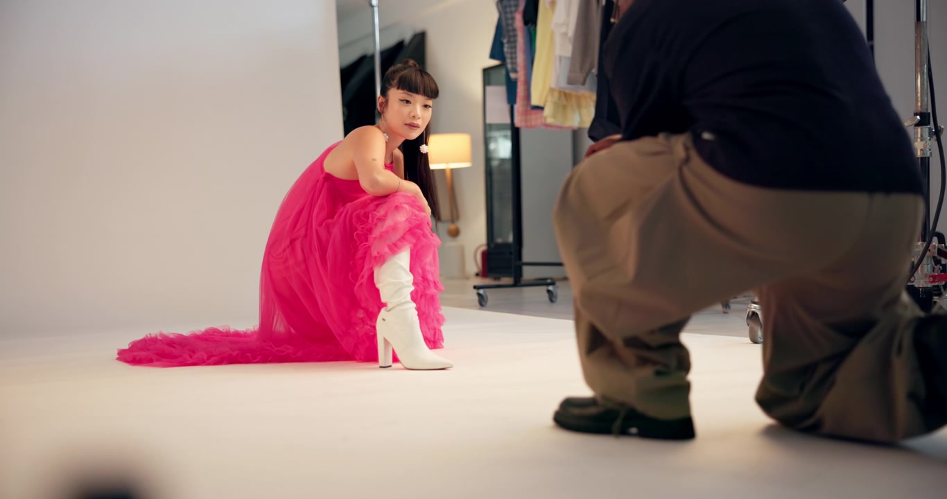 Modefotograf tager billeder af model i lyserød kjole