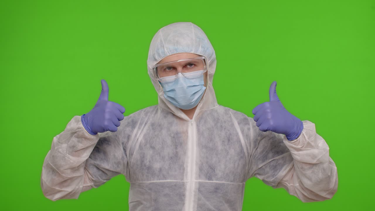 Medical doctor showing thumbs up sign, like gesture, satisfied with successful defeating coronavirus