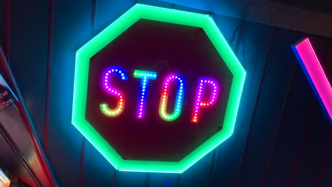 neon illuminated stop sign glowing in many different colors