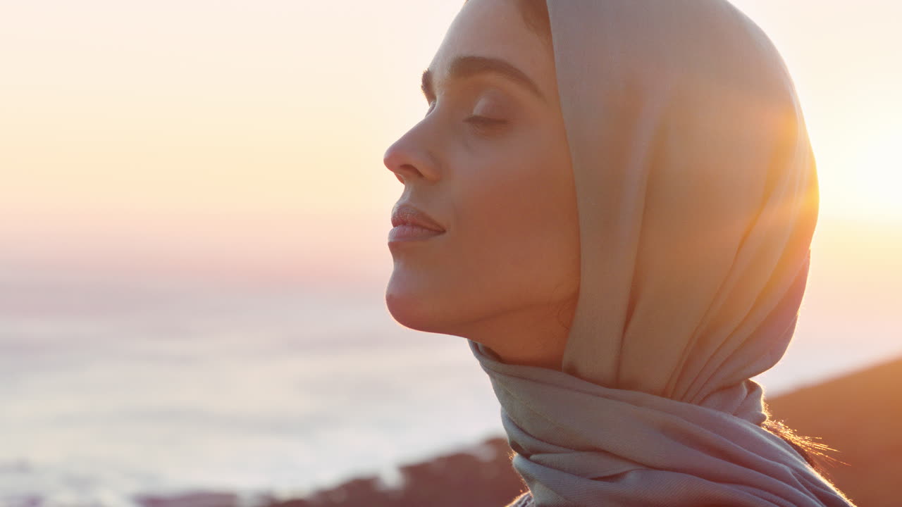 아름다운 무슬림 여성의 초상화 영성을 탐구하고 평화롭게 느끼고 해가 지는 것을 즐기는 히자브 헤드 스카프를 착용하고 있습니다.