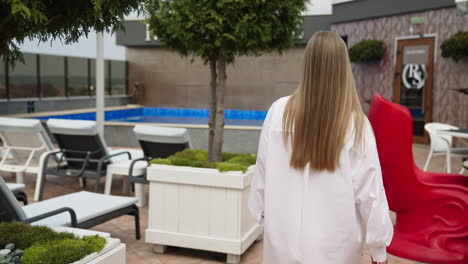woman on a rooftop patio by a pool