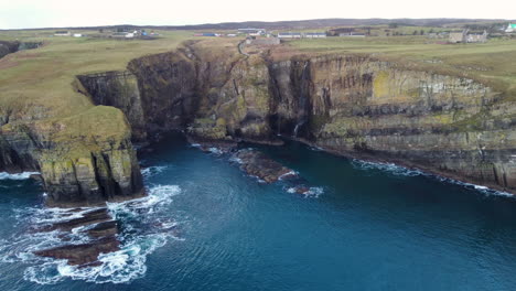 drone shot of the cliffs and waterfall at whaligoe in scotland uk