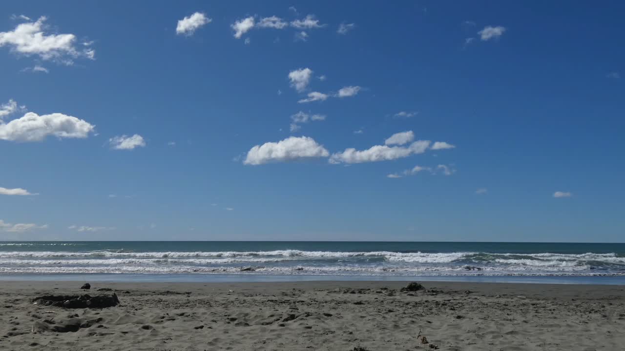 구름은 아름다운 여름날 작은 파도가 모래사장으로 밀려들면서 거의 움직이지 않는 것처럼 보입니다 - 서머 비치