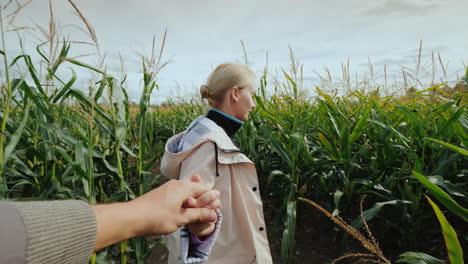 a young woman farmer invites you to visit the corn maze by following the hand behind her