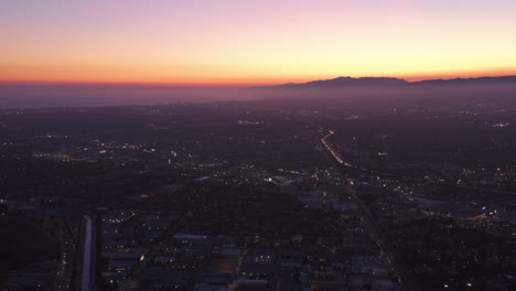 Amplia-Vista-Aérea-De-Los-ángeles-Y-Santa-Monica,-California-Hacia-El-Océano-Pacífico-Desde-Culver-City-Al-Atardecer,-Noche-Con-Cielo-Púrpura-Y-Luces-De-Ciudad-Brillantes-Con-Silueta-De-Montaña