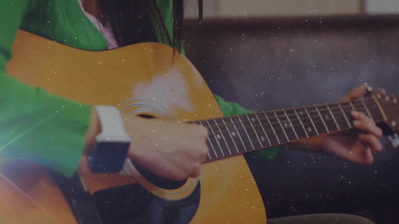 Una chitarrista posa la mano sulla chitarra, iniziando a strimpellare per esercitarsi con la musica, con scintille.
