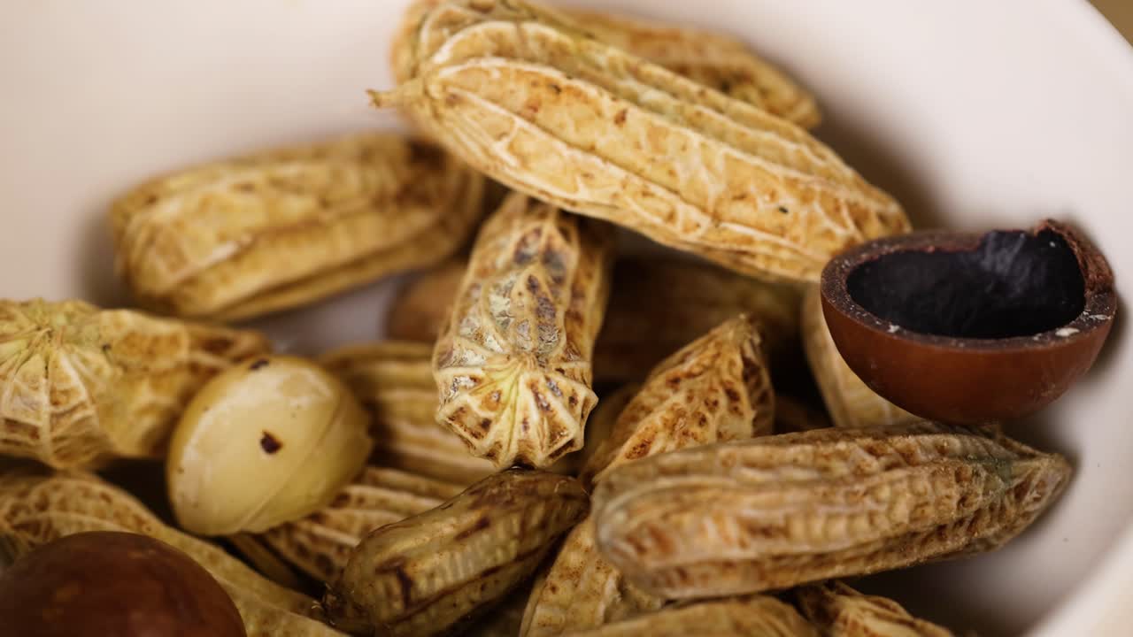 Peanuts and chestnuts arranged in a white bowl