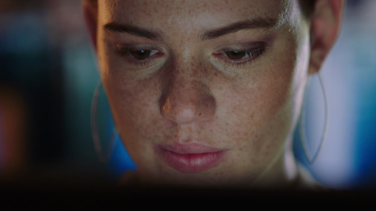 close up portrait beautiful woman using tablet computer browsing internet looking at screen working late