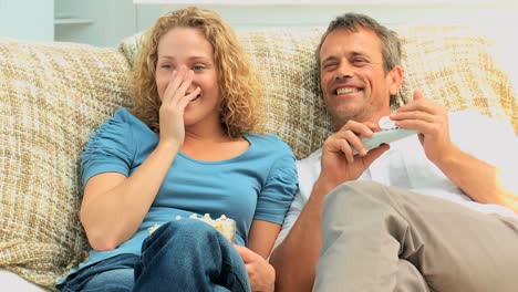couple laughing in front of the tv