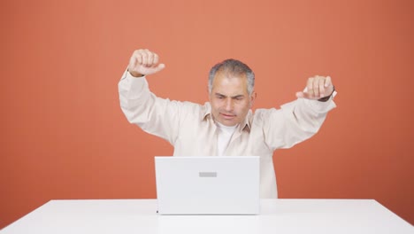 el hombre que mira la computadora portátil está feliz y bailando.