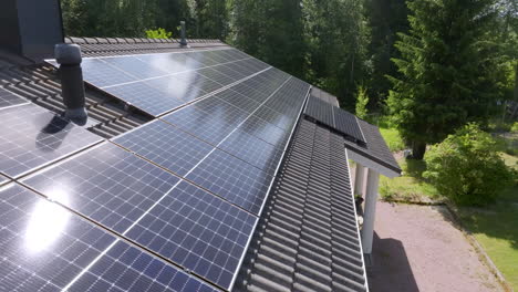 aerial close-up to the surface of mirroring solar cells on a roof, summer day