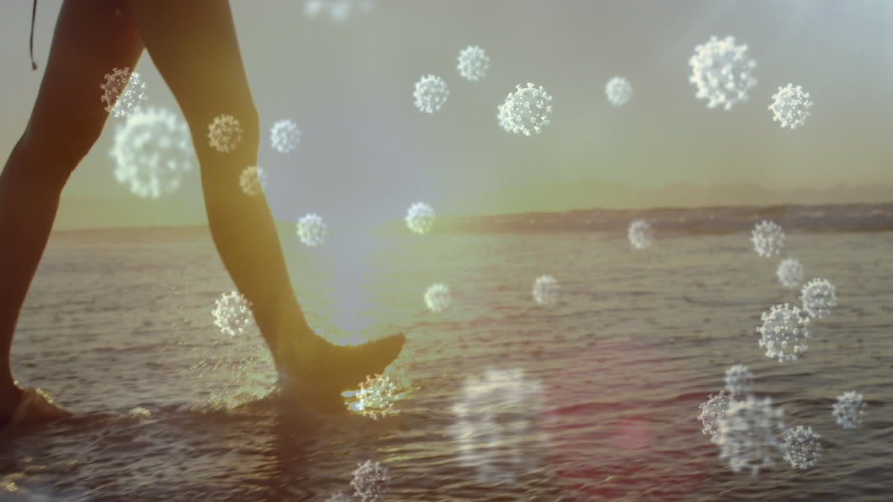 해변에서  ⁇ 고 있는 여성의 낮은 부분을 향해 움직이는 코로나19 세포의 디지털 복합 비디오