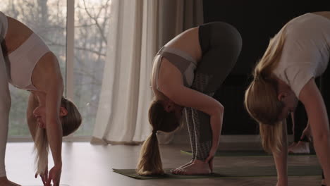 young caucasian sporty people practicing yoga lesson with instructor. caucasian group of women exercising healthy lifestyle in fitness studio. sport activity gymnastics class. slow motion.