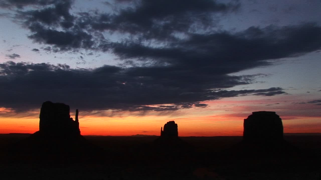 Totaalshot van The Mittens in Monument Valley, Arizona, afgetekend tijdens het gouden uur.