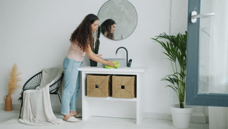 woman cleaning a bathroom sink
