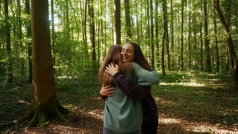 two women embracing in a sunny forest