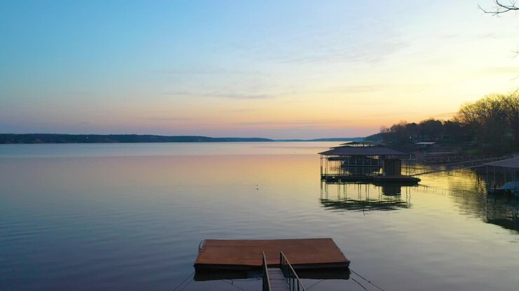Acqua calma come uno specchio e pontili galleggianti per barche sul Grand Lake O' the Cherokee in Oklahoma, in riva al lago