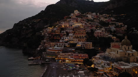 Aéreo:-Al-Revés-Revela-Una-Toma-De-Positano-En-La-Costa-De-Amalfi,-Italia,-Durante-La-Puesta-De-Sol