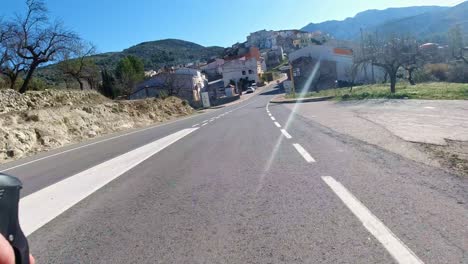 High-in-the-mountains-of-rural-Alicante-Spain,-cycling-into-a-small-village-on-a-training-ride