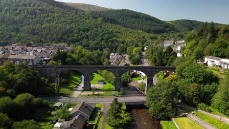 an aerial drone shot of a beautiful valley in south wales with an old viaduct