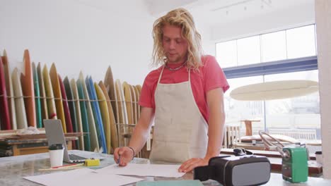 Caucasian-male-surfboard-makers-working-in-his-studio