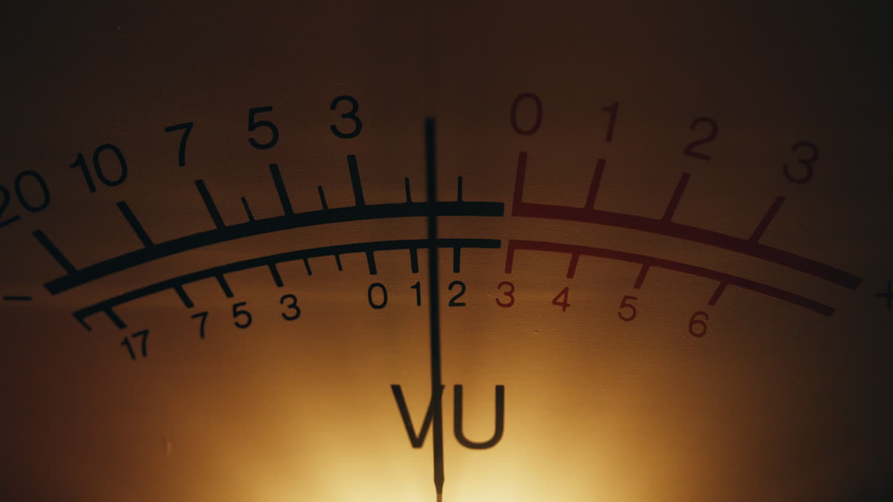 Analog dial indicator of audio signal level closeup. Vintage arrow moving inside