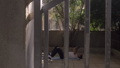 hombre haciendo abdominales en la alfombra en el patio