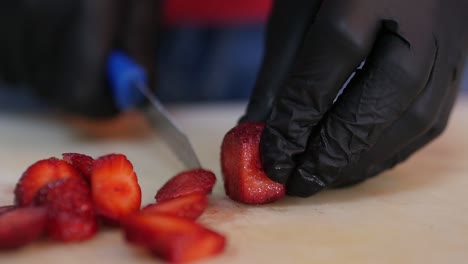 Primer-Plano-De-Fresas-Frescas-En-Rodajas-Mientras-Usa-Guantes-De-Seguridad-Alimentaria