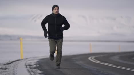 a warmly dressed traveler walks alone on a remote road, surrounded by the vast, snow-covered mountains of an icelandic winter landscape
