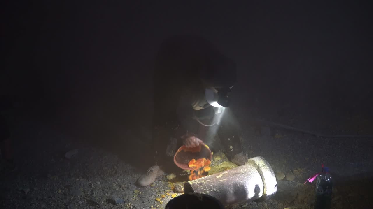 자바의 광부 한 명이 인도네시아 동자바의 이젠 산에서 밤중에 작은 버에서 황을 추출하고 있습니다.