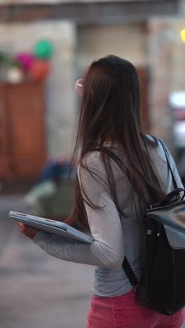 una adolescente caminando con una tableta